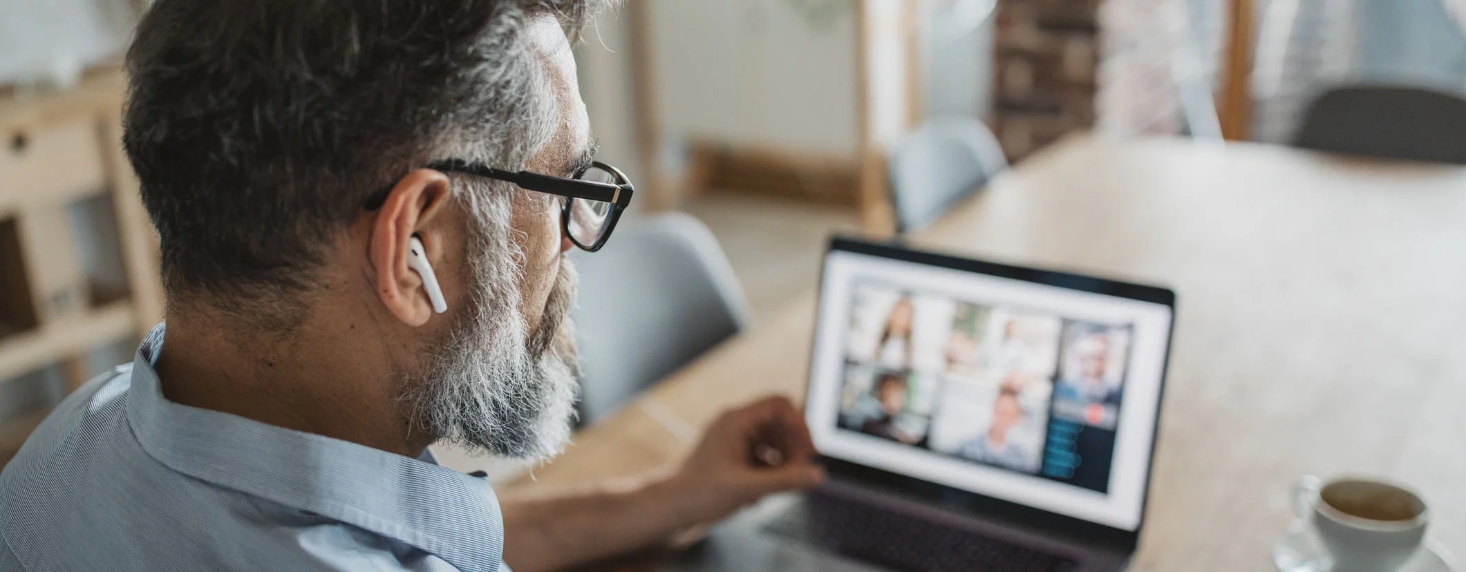 Leader focused on executive productivity, participating in a video conference on his laptop. The image highlights the use of virtual assistant services to enhance efficiency in a remote work environment.