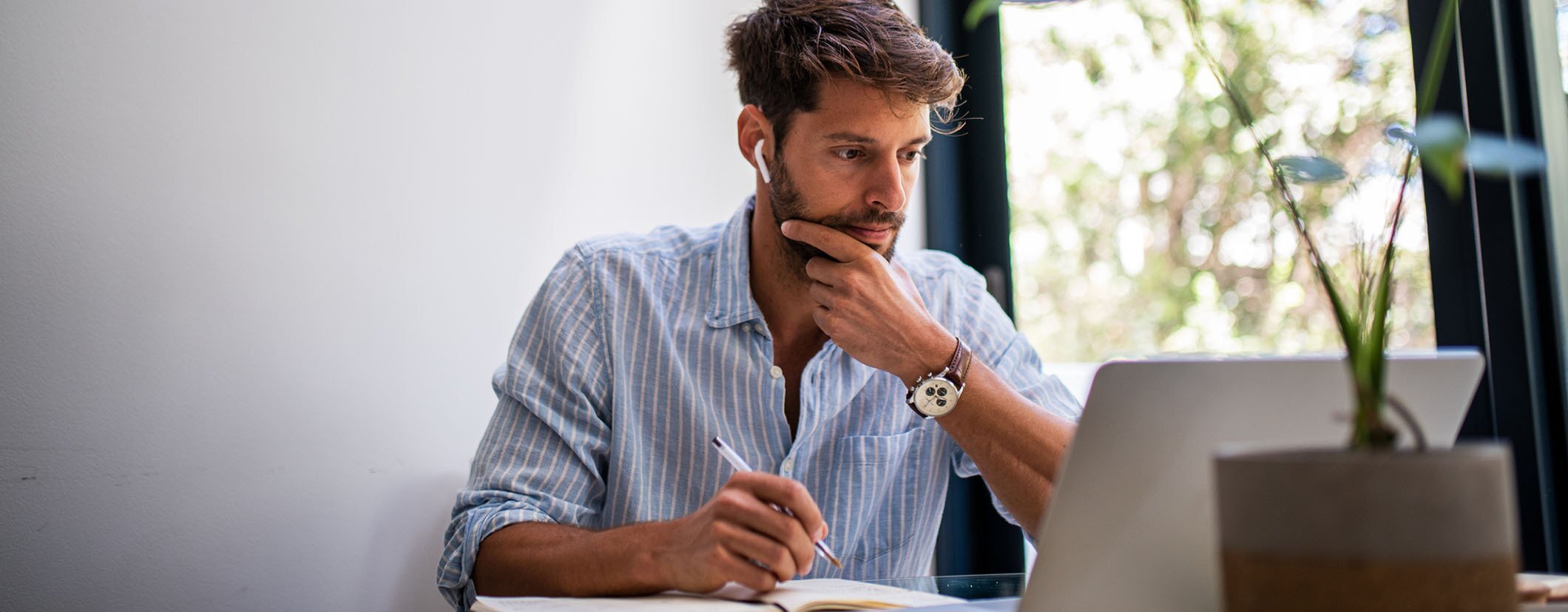 A modern looking bearded executive focuses intently on a laptop screen during a virtual meeting. The image illustrates executive productivity and the use of virtual assistant services for tech CEOs and founders, where leaders can leverage virtual assistant services to streamline tasks and free up time.