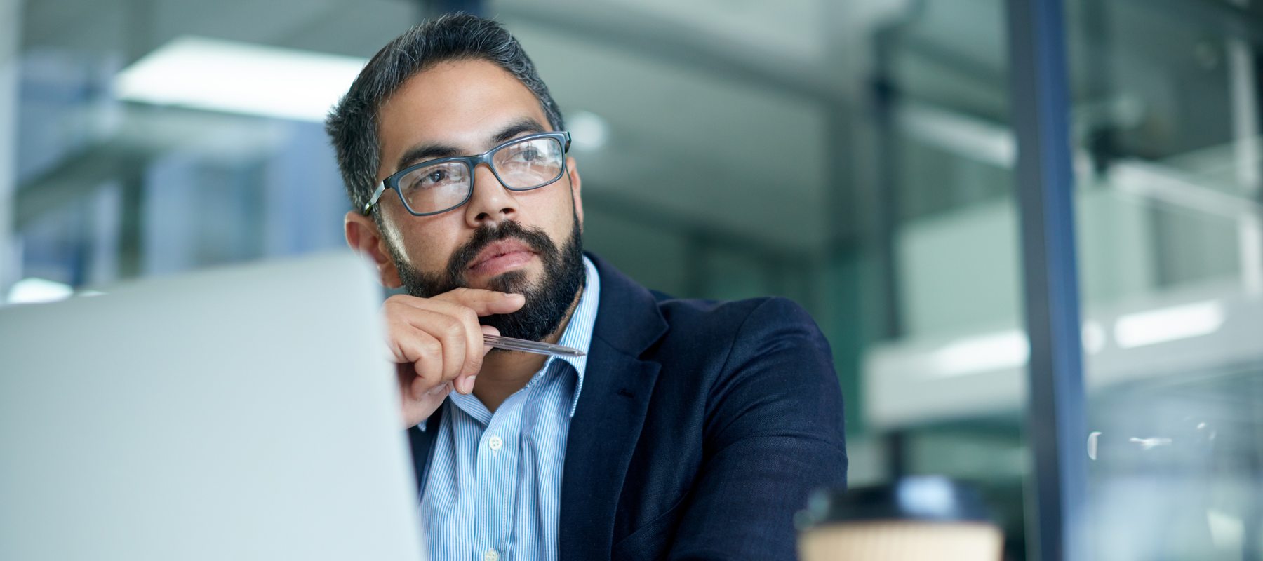 Man sitting at computer looking off into the distance