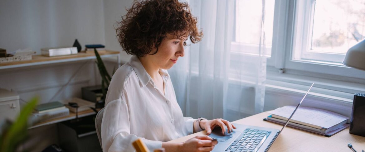 Woman sitting at computer, looking at screen