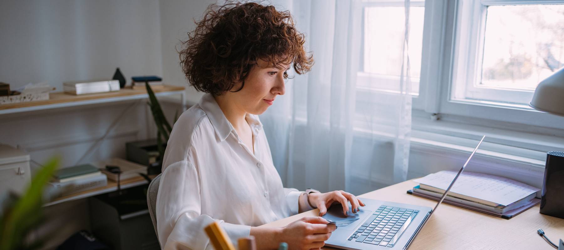 Woman sitting at computer, looking at screen