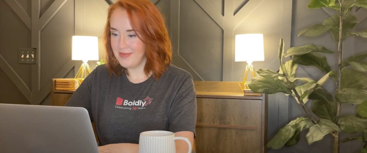 Woman with Boldly shirt on sitting at a computer and working